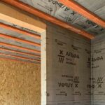 дерев'яні сходи всередині двоповерхового каркасного будинку